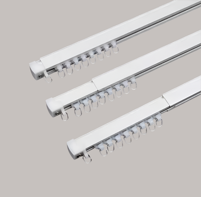 Three white curtain rods with hooks on a white background